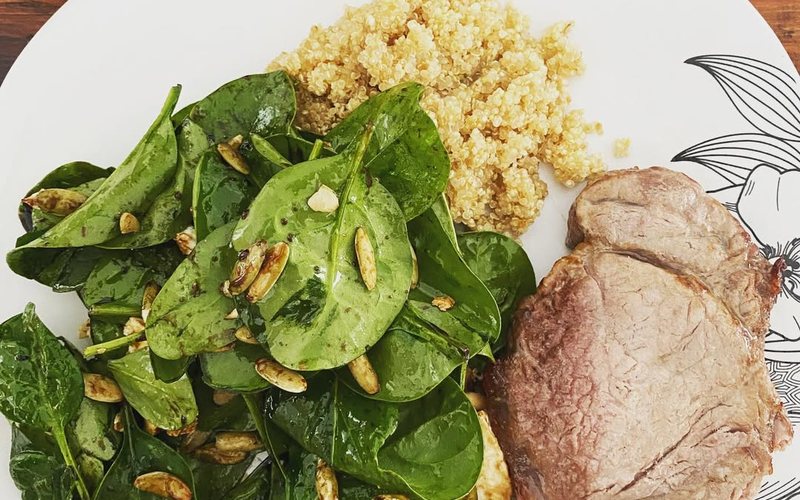 Plate of spinach, seeds, quinoa and lean meat
