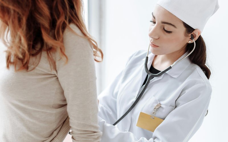 Doctor listening carefully during a woman's checkup