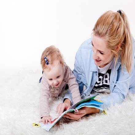 Mother reading a picture book with her baby