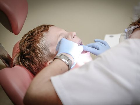 Child having a gentle dental check in the dentist's chair