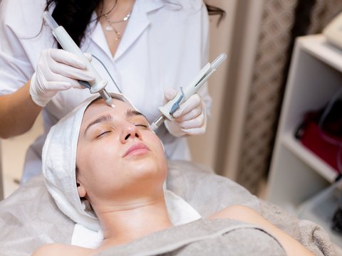 Woman relaxing during a professional facial skin treatment