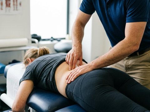 Therapist easing lower back pain with hands-on treatment