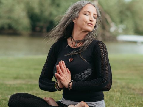 Woman meditating calmly in a park