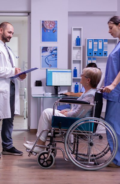 Doctor and nurse caring for an older patient in a wheelchair